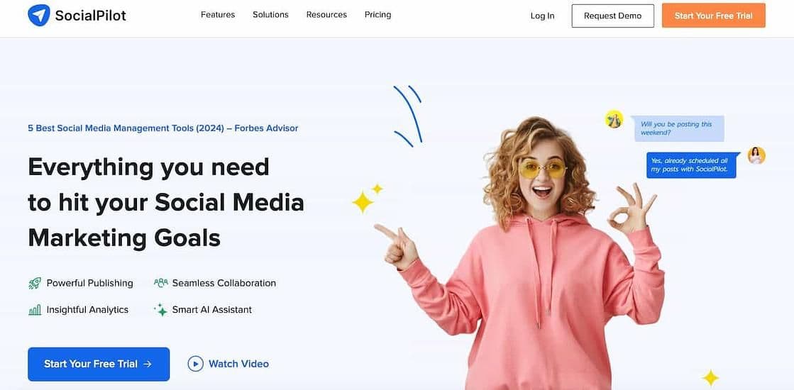 Image 7: socialpilot homepage with a woman wearing a pink hoodie making an ok sign with one hand and another hand pointing at text that reads everything you need to hit your social media marketing goals
