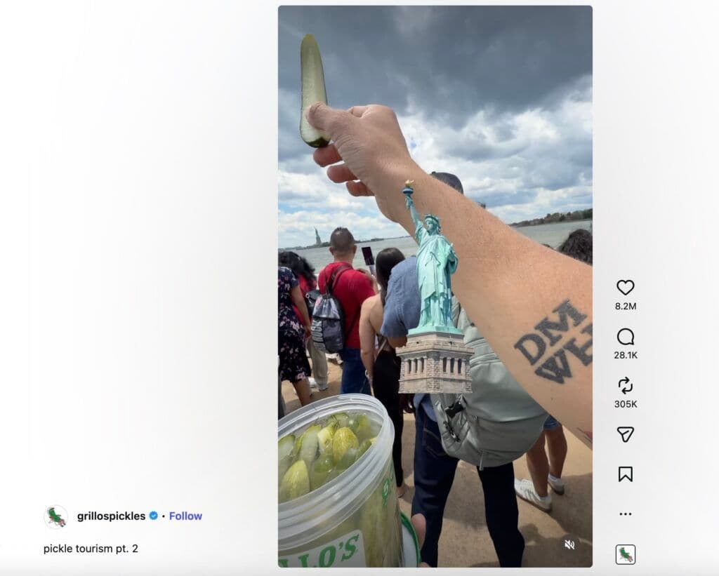 Image 9: An image form the Grillo's Pickles page of people showing the Statue of Liberty to a pickle.